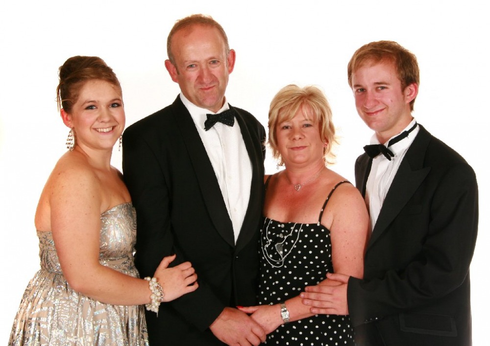 A family in formalwear photographed together at an evening event