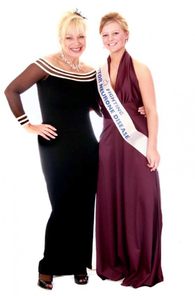 Two guests in evening gowns, one wearing a ceremonial sash, at a formal event