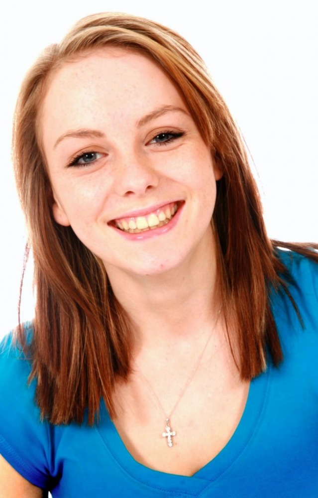 Smiling young woman in a blue top, studio family portrait
