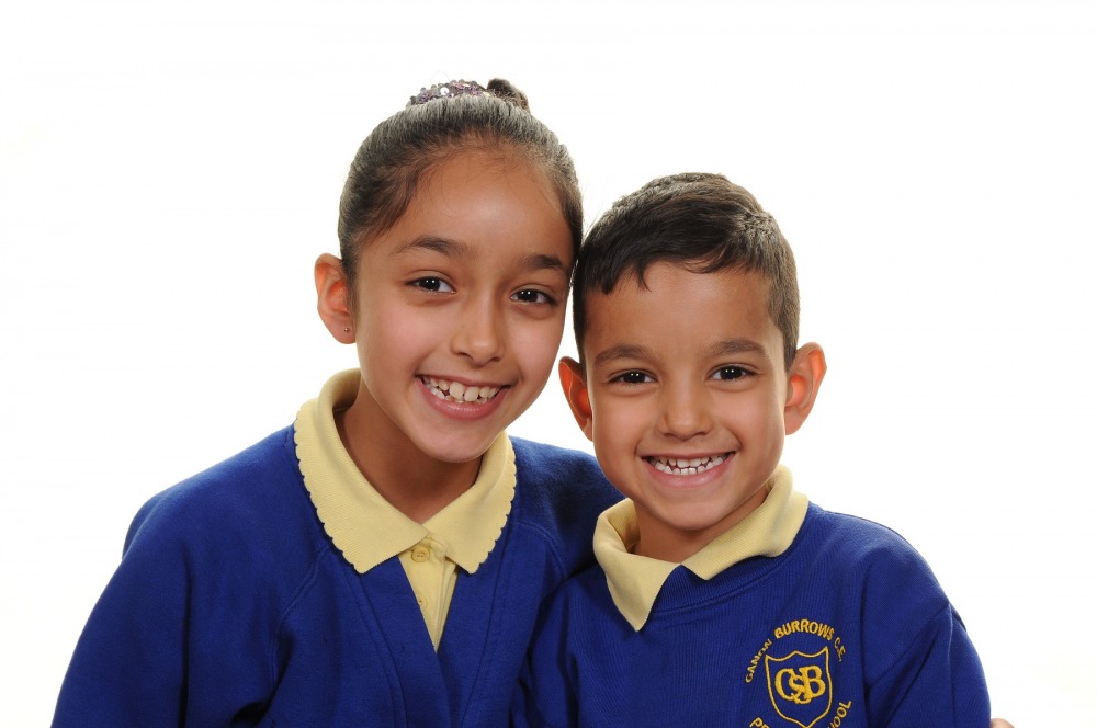 A brother and sister in navy school uniforms photographed together